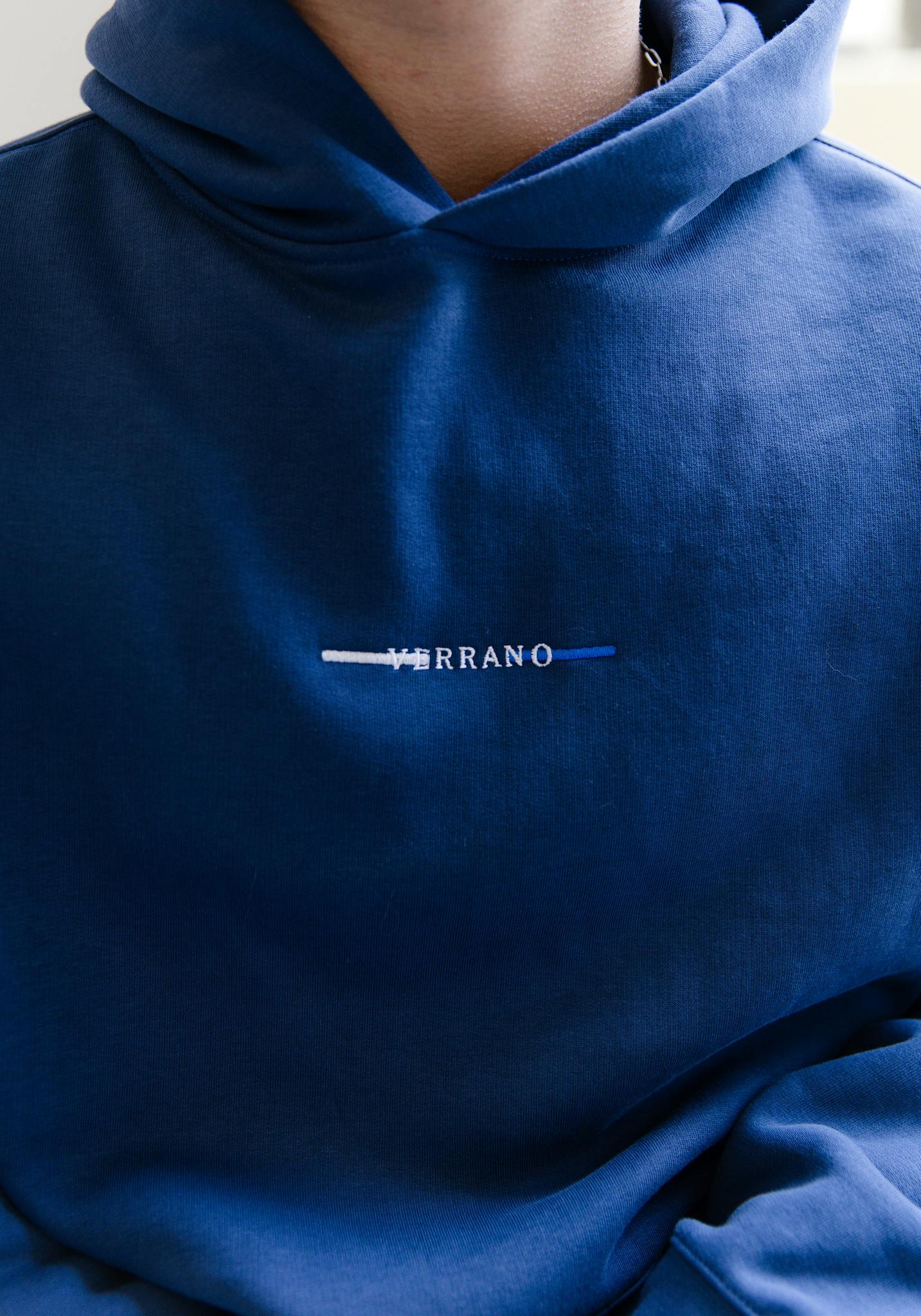 A detailed shot of a blue hoodie featuring a unique embroidered design.